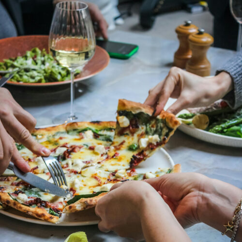 Weeknight Dinner Deals In Hong Kong: friends sharing a pizza and wine