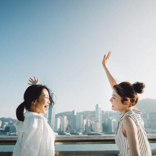 how to make friends in hong kong two women waving at each other