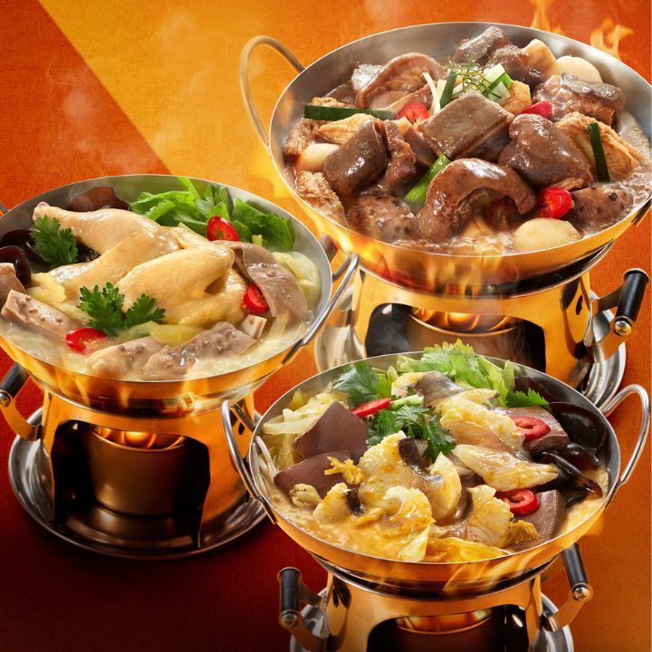 Trio of noodle dishes in individual brass pots with chicken, mushrooms and seafood on orange background.